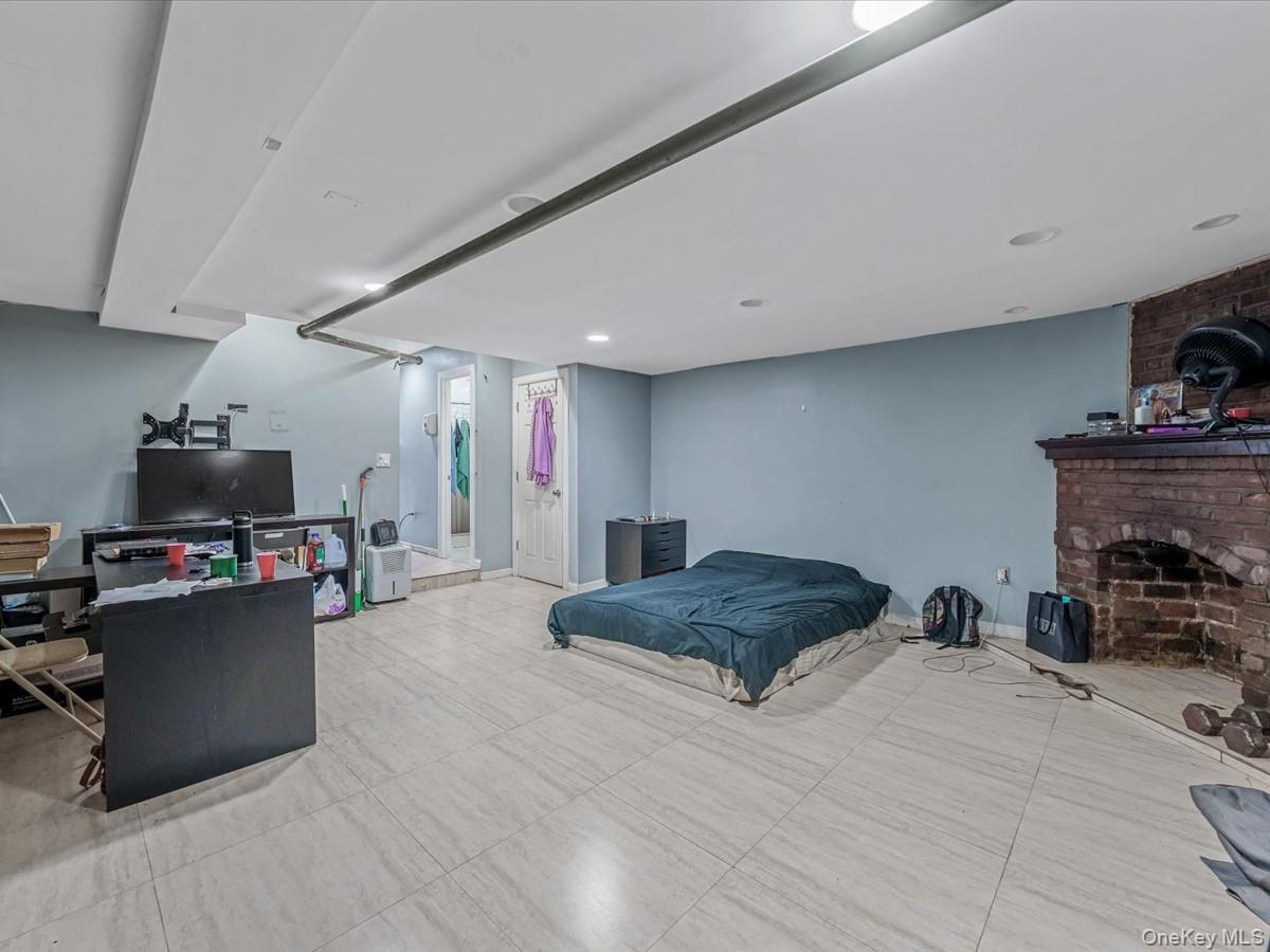 172-09 Sayres Avenue Queens, NY 11433 - Photo 18 of 23 a bedroom with a bed gym equipment and a fireplace