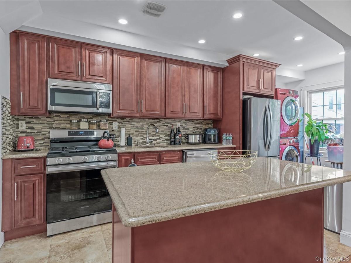 172-09 Sayres Avenue Queens, NY 11433 - Photo 7 of 23 a kitchen with stainless steel appliances granite countertop a stove microwave and cabinets