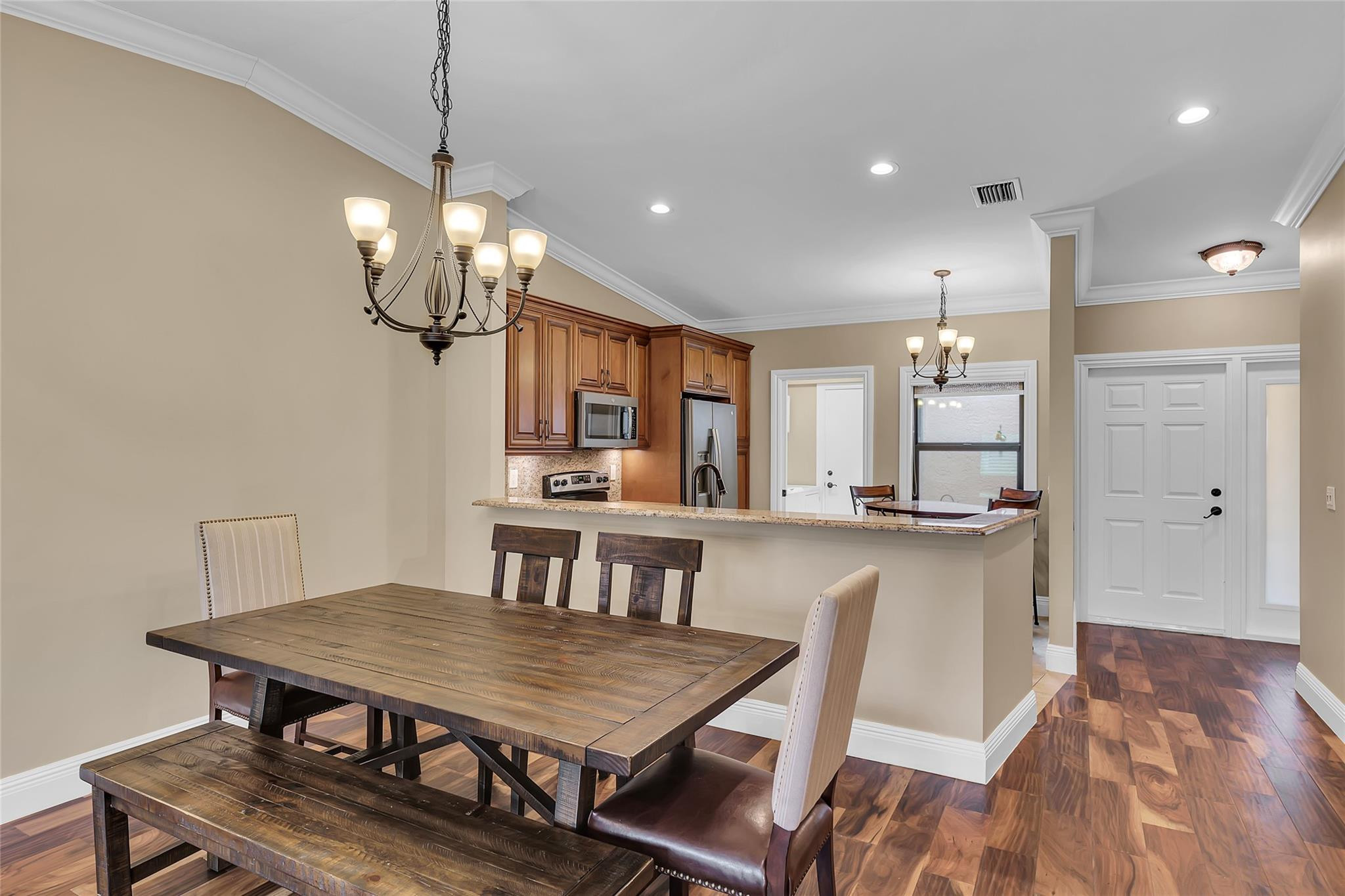 8306 Springlake Drive, Unit C Boca Raton, FL 33496 - Photo 11 of 44 a dining room with kitchen island a table and chairs