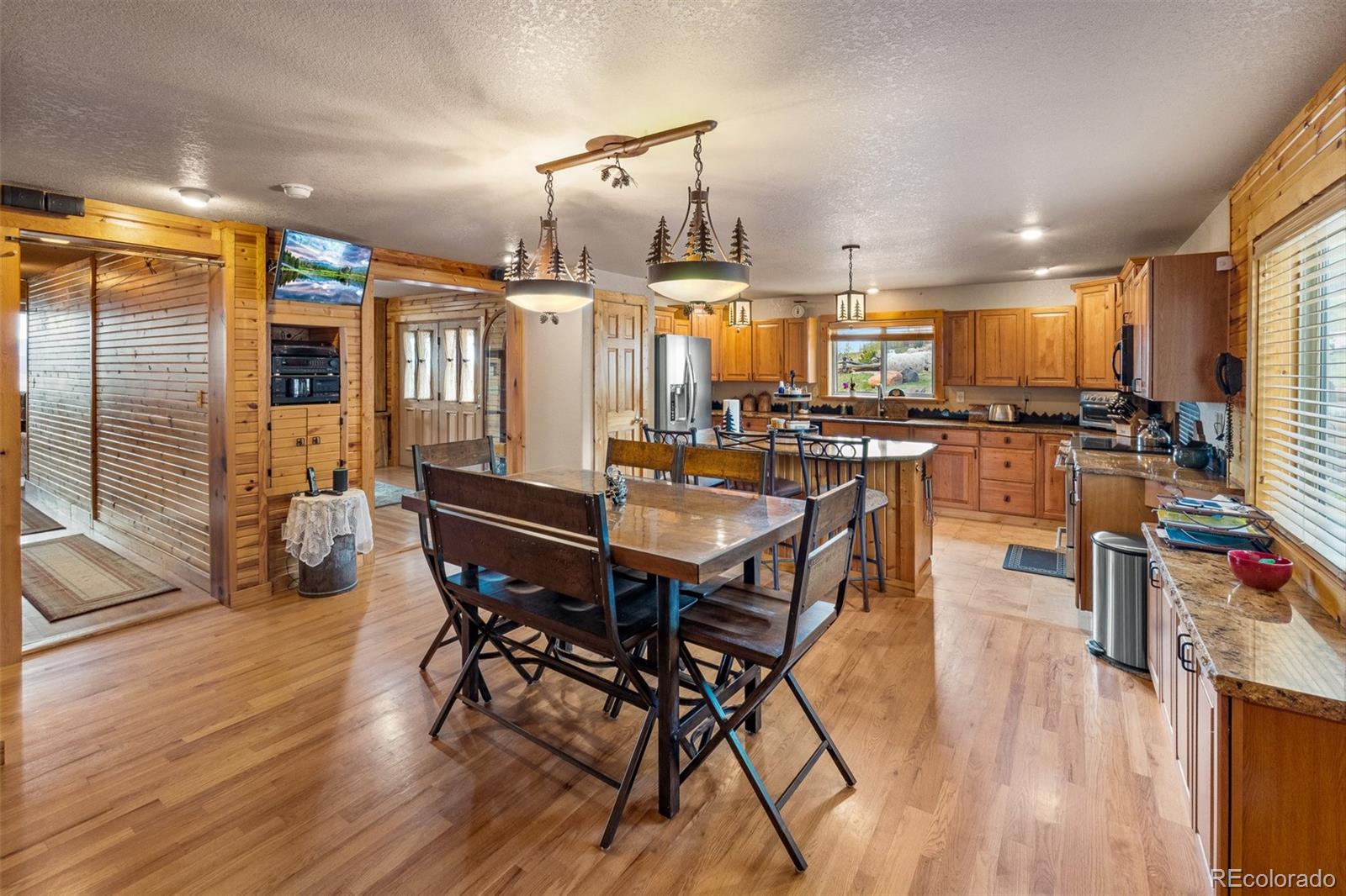 1163 Michigan Hill Road Jefferson, CO 80456 - Photo 6 of 48 a dining room with wooden floor a glass table and chairs