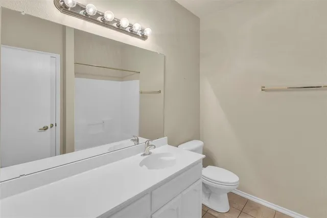 an empty room with a chandelier fan and windows