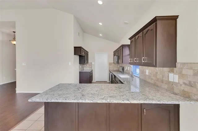 a kitchen with granite countertop a sink a refrigerator and a granite counter tops