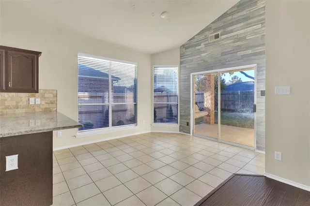 a view of an empty room with a fireplace and a window