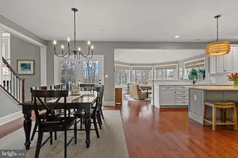 a view of a dining room and livingroom with furniture wooden floor a chandelier