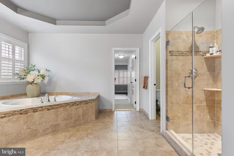 a bathroom with a tub sink and mirror
