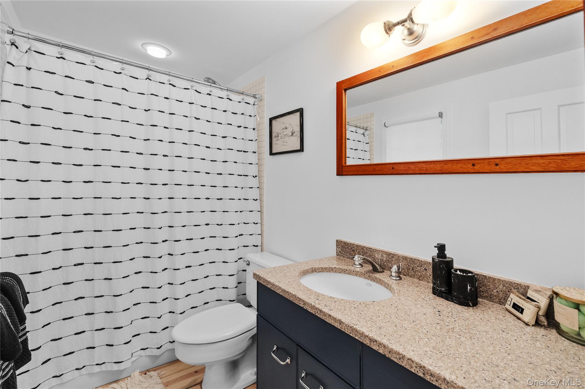 197 Hog Creek Road East Hampton, NY 11937 - Photo 16 of 17 a bathroom with a granite countertop toilet a sink and a mirror