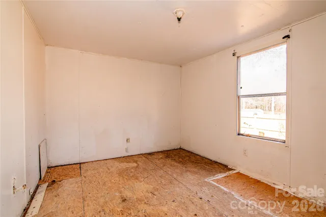a view of a room with wooden floor and window