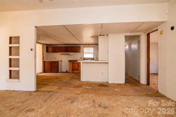 a view of an empty room with a fireplace and a window