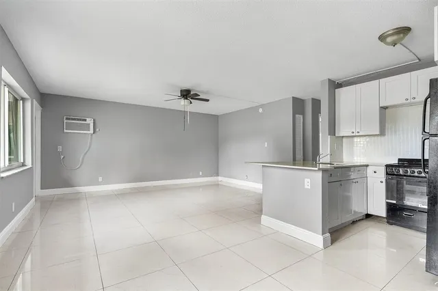 a kitchen with a white refrigerator freezer a sink dishwasher and a refrigerator with wooden floor