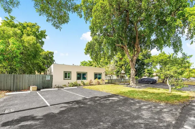 a view of a house with backyard and a tree