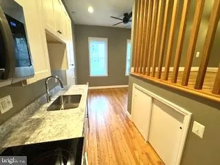 a view of a kitchen with a sink and wooden floor