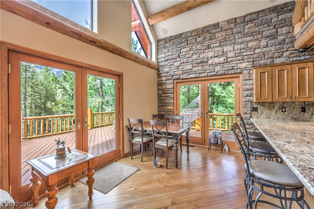 322 Ski Trail Road Mount Charleston, NV 89124 - Photo 10 of 58 Gleaming hardwood floors and a towering stone wall define this inviting mountain dining area.