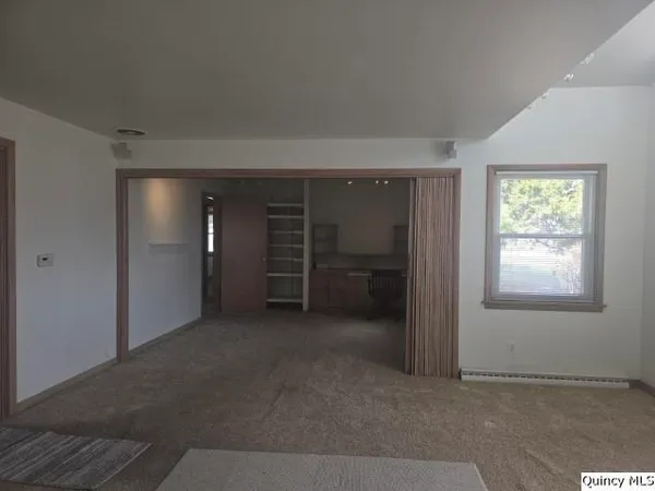 an empty room with closet and a window