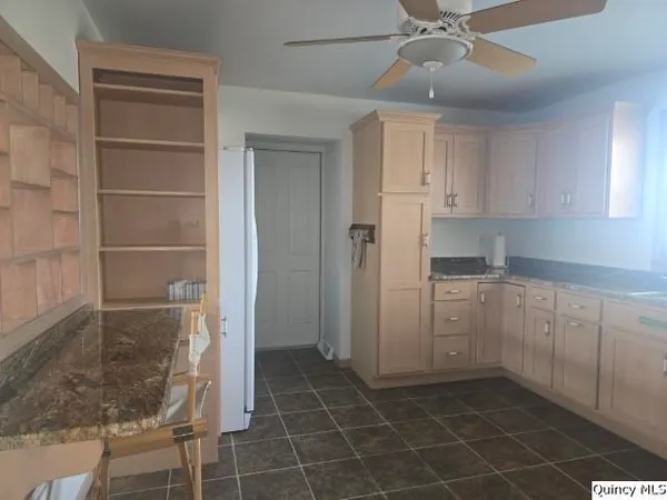 a kitchen with a refrigerator and table chair