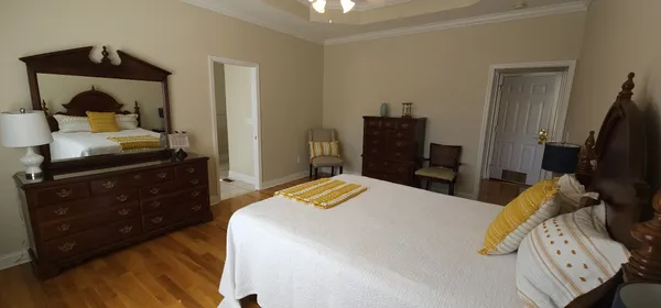 a bedroom with a bed and a flat tv screen on a dresser