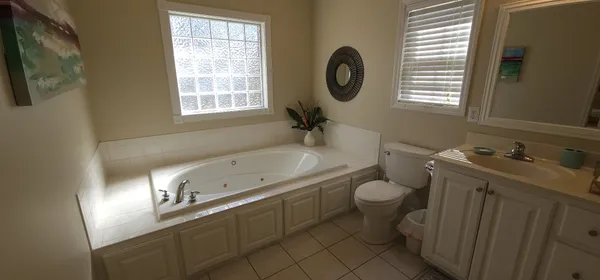 a bathroom with a granite countertop toilet sink and mirror