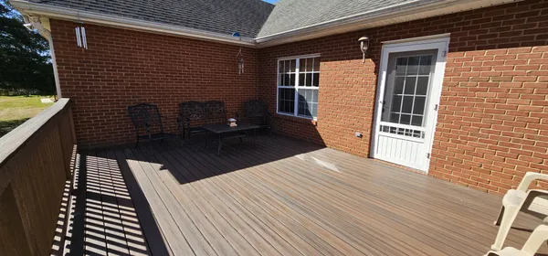 a view of a balcony with wooden floor and fence