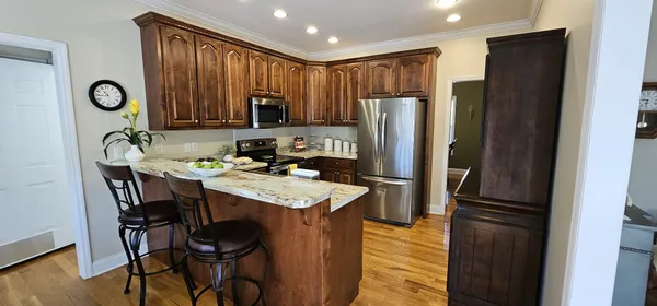 a kitchen with stainless steel appliances granite countertop a refrigerator stove microwave and sink