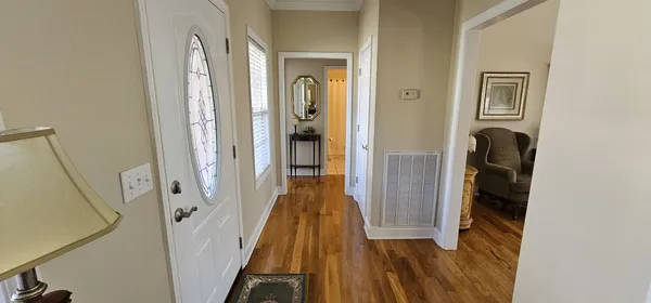 a view of a hallway with wooden floor and closet
