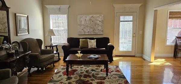 a living room with furniture and wooden floor