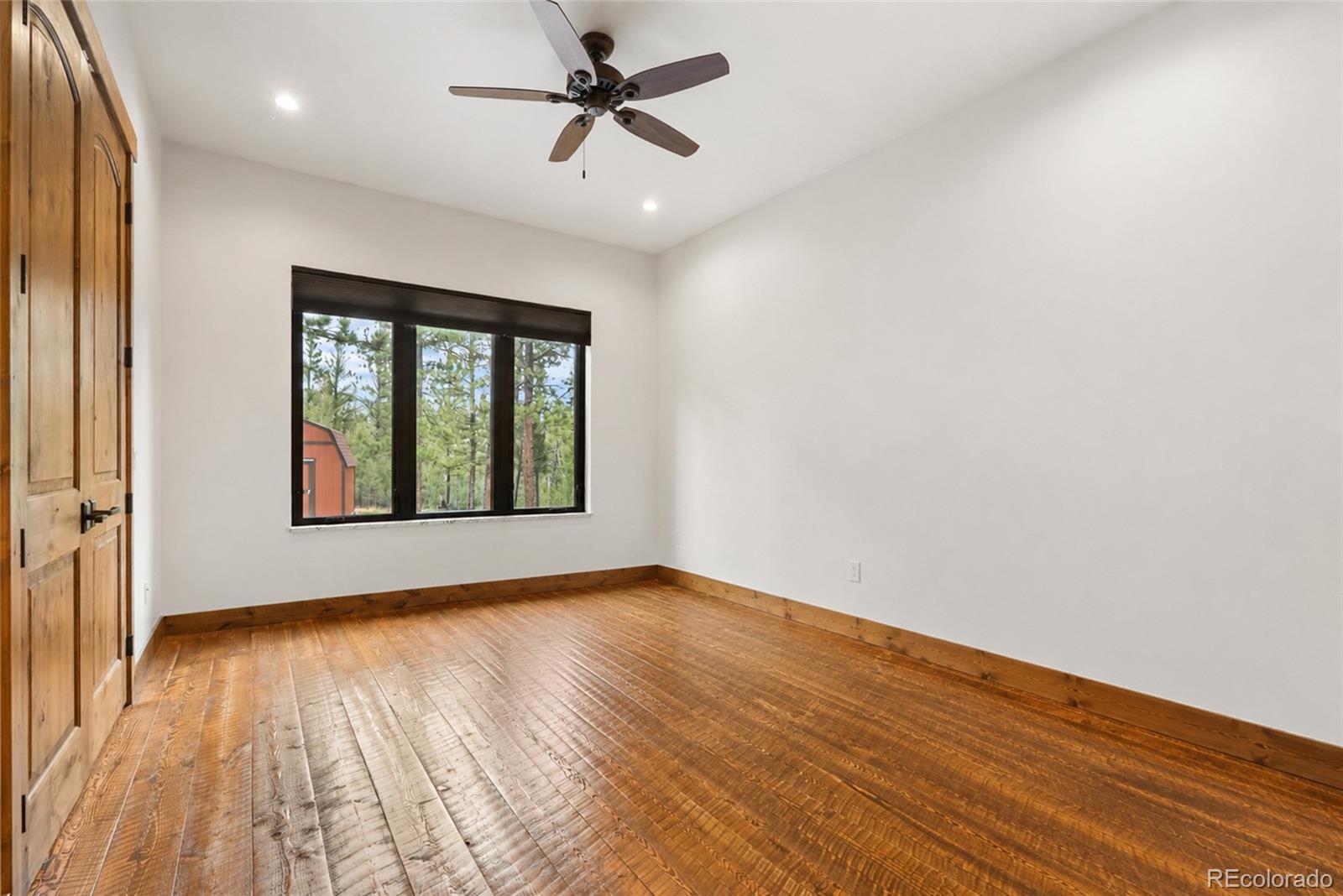 280 Double Tree Road Bailey, CO 80421 - Photo 21 of 43 a view of empty room with wooden floor and fan