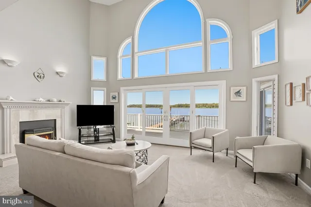 a living room with furniture a wooden floor and a large window