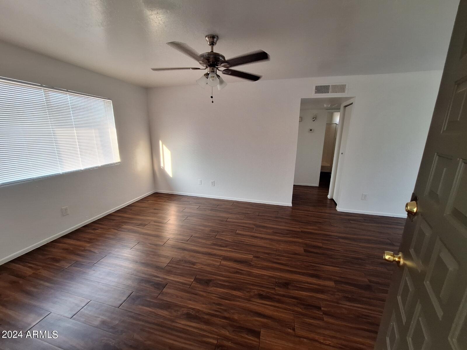 2029 North Hunt Circle, Unit 202 Mesa, AZ 85203 - Photo 1 of 9 a view of empty room with wooden floor and fan