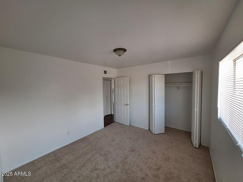 2029 North Hunt Circle, Unit 202 Mesa, AZ 85203 - Photo 4 of 9 a view of an empty room and a window