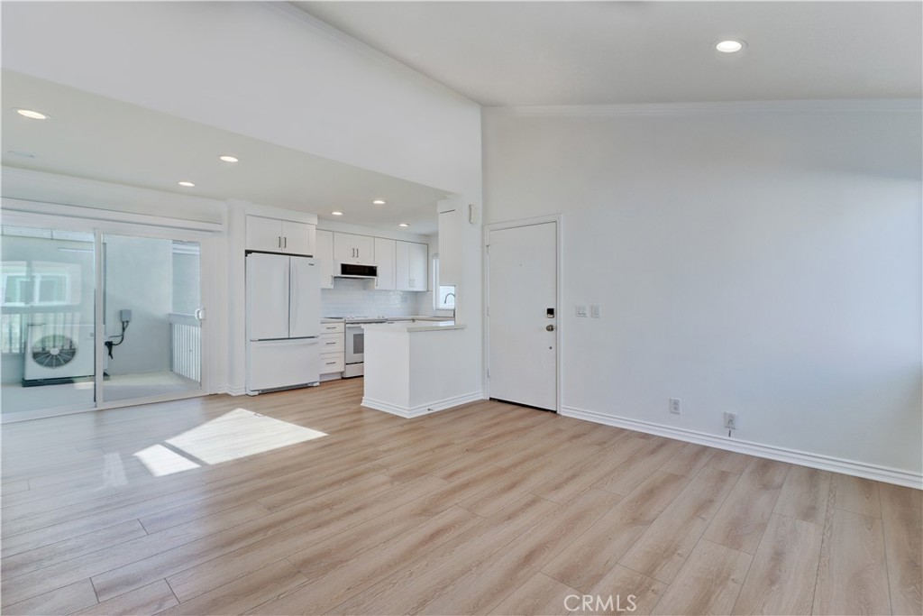 34026 Selva Road, Unit 65 Dana Point, CA 92629 - Photo 3 of 21 a view of an empty room with wooden floor and kitchen