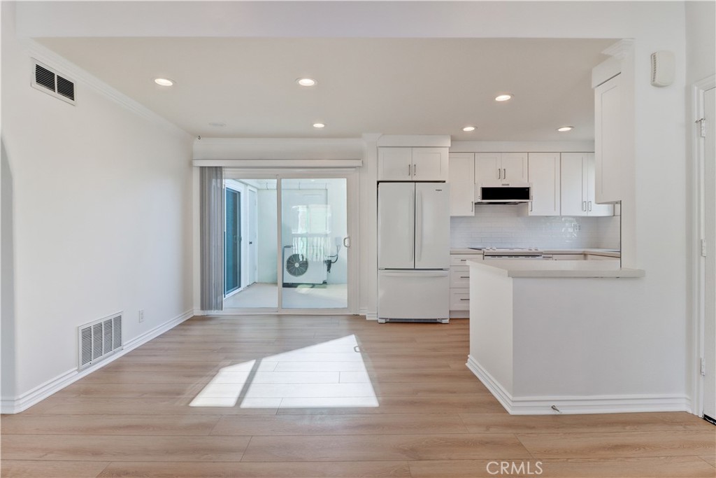 34026 Selva Road, Unit 65 Dana Point, CA 92629 - Photo 5 of 21 a open kitchen with white cabinets and wooden floor