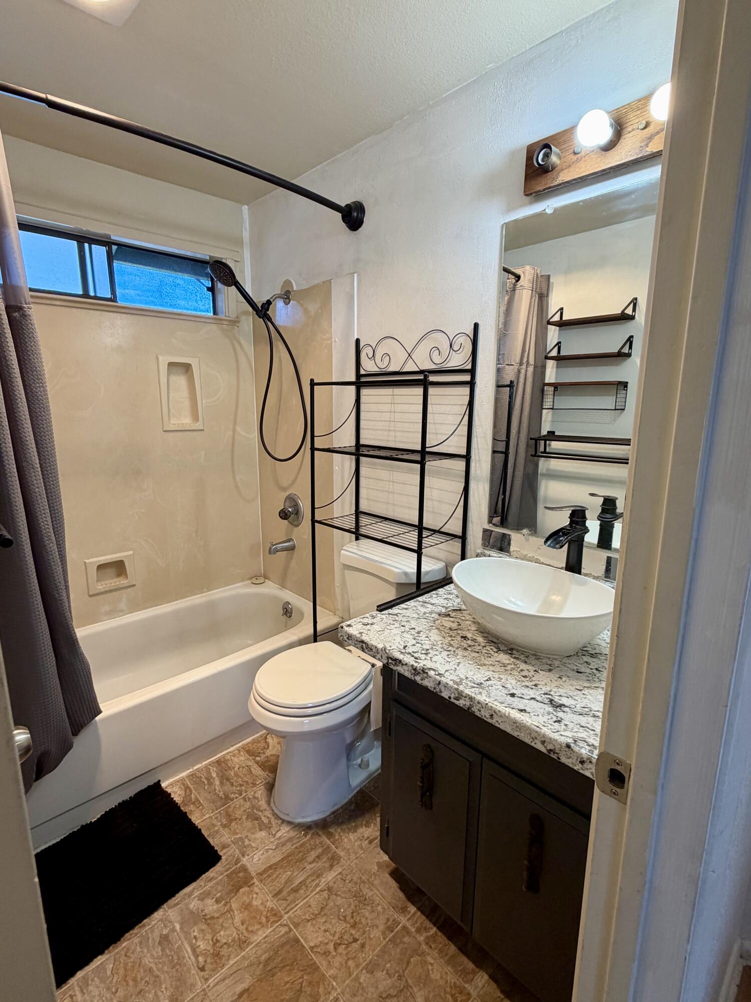 1198 Morrow Road, Unit A Medford, OR 97504 - Photo 16 of 20 a bathroom with a granite countertop sink toilet and shower