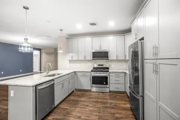 a kitchen with stainless steel appliances granite countertop a sink stove and refrigerator