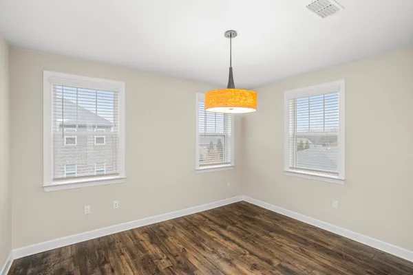 an empty room with a chandelier fan