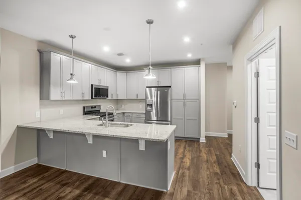 a kitchen with stainless steel appliances granite countertop a sink refrigerator and cabinets