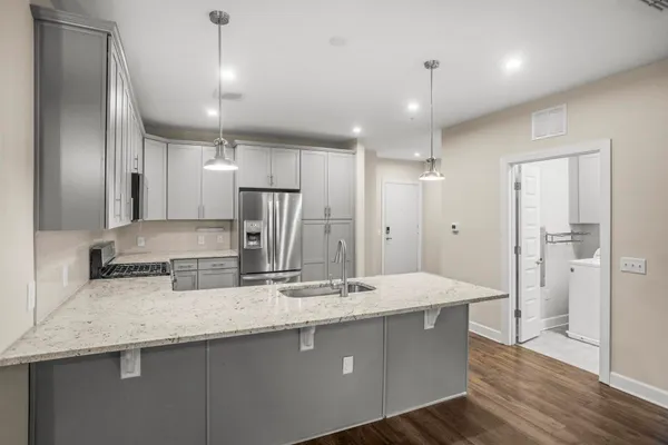 a kitchen with stainless steel appliances a sink stove refrigerator and cabinets