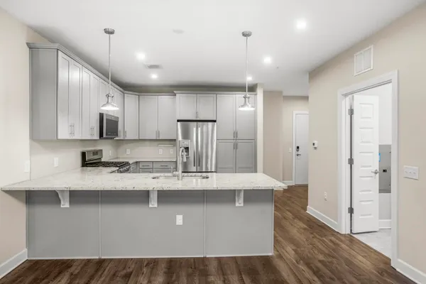 a large kitchen with stainless steel appliances lots of counter space and wooden floor