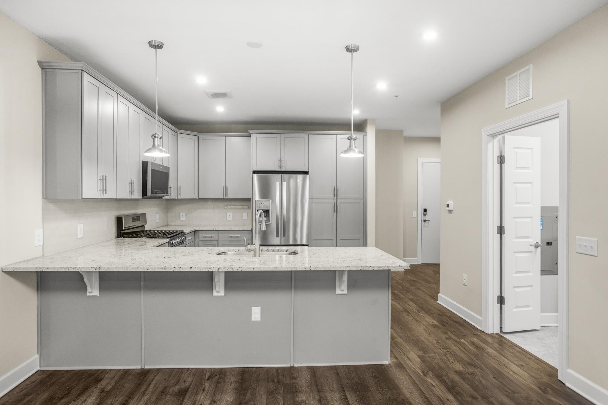 141 Saundersville Road, Unit 1402 Hendersonville, TN 37075 - Photo 7 of 60 a large kitchen with stainless steel appliances lots of counter space and wooden floor