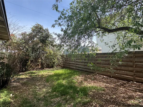 a view of a yard with wooden fence