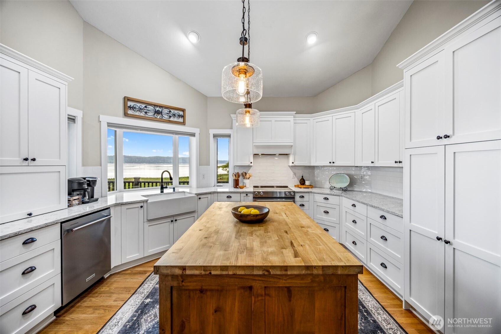 6591 Northeast North Shore Road Belfair, WA 98528 - Photo 16 of 37 a kitchen with a stove a sink dishwasher a refrigerator and white cabinets with wooden floor