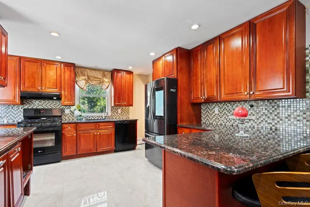 a kitchen with stainless steel appliances granite countertop wooden cabinets a stove top oven a sink and dishwasher
