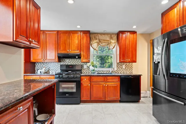 a kitchen with stainless steel appliances granite countertop a stove a sink and a refrigerator