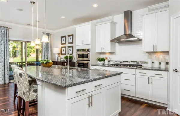 a kitchen with stainless steel appliances granite countertop a kitchen island a stove and a sink