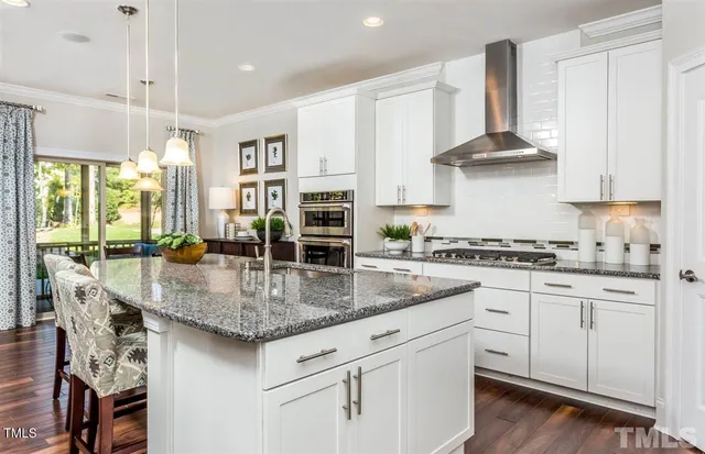 a kitchen with stainless steel appliances granite countertop a kitchen island a stove and a sink