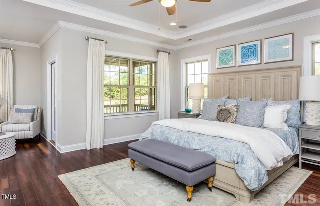 a spacious bedroom with a bed and wooden floor