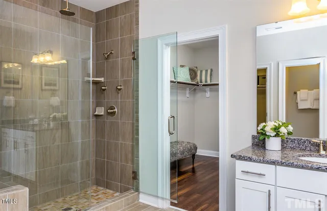 a bathroom with a granite countertop shower a sink and mirror
