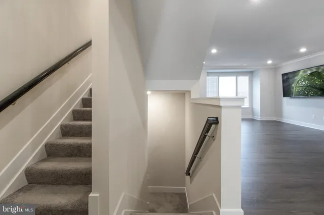 a large kitchen with stainless steel appliances kitchen island granite countertop a refrigerator a oven a stove and a sink with wooden floor