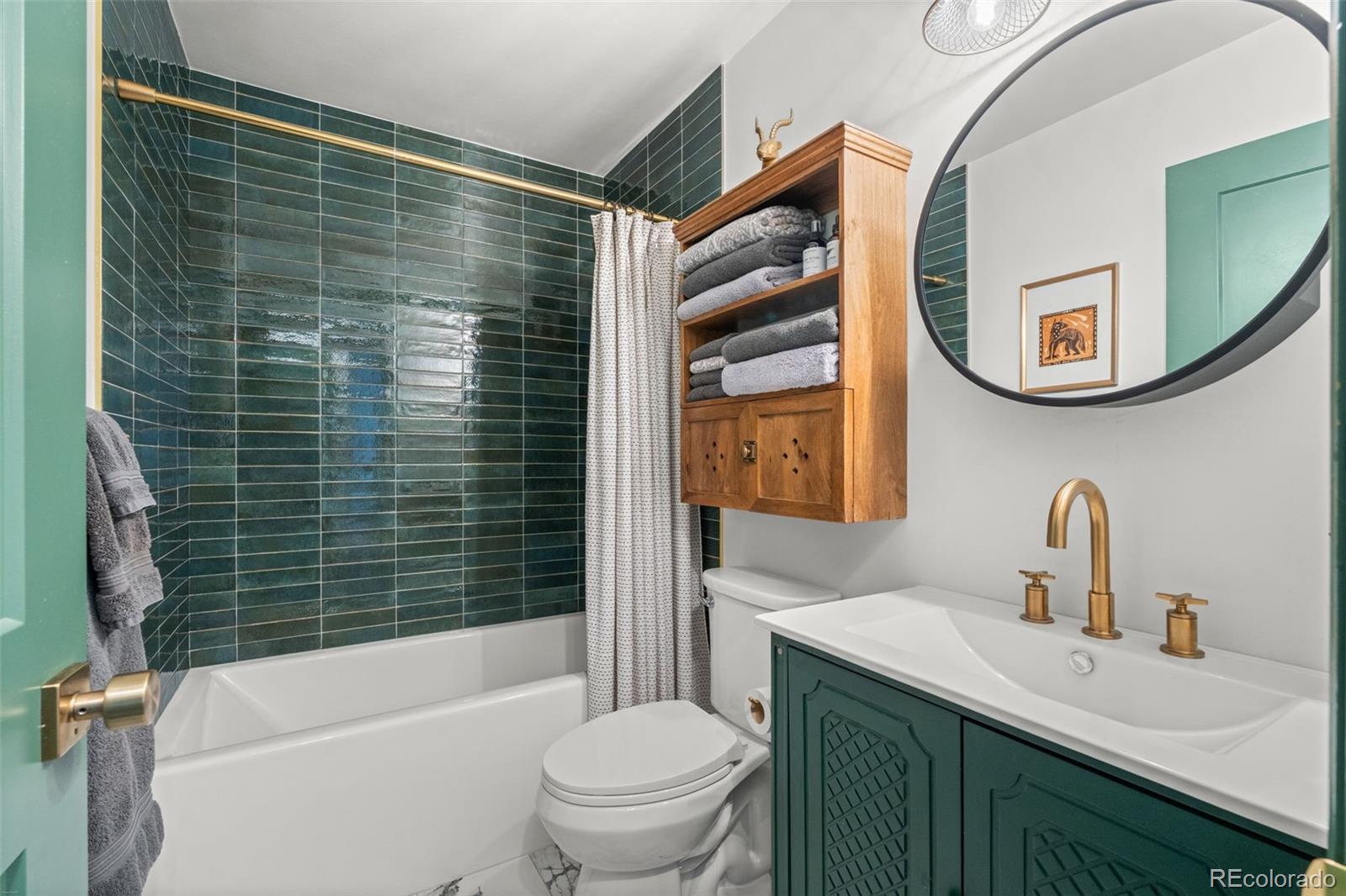 12159 Circle Drive Conifer, CO 80433 - Photo 33 of 49 a bathroom with a sink a toilet a mirror a vanity and bathtub