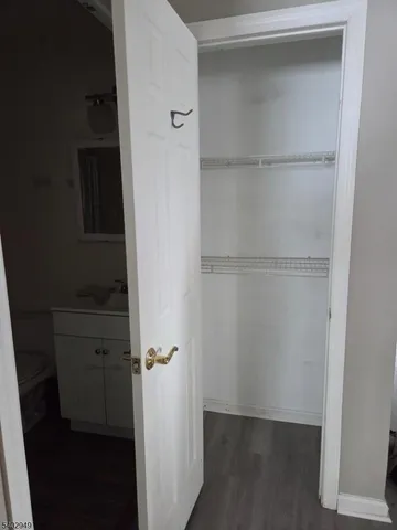 an empty room with wooden floor ceiling fan and windows