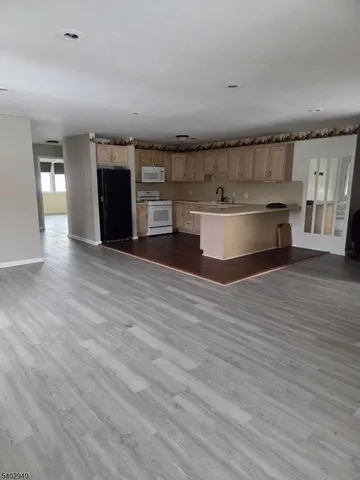 a view of kitchen with granite countertop cabinets and wooden floor
