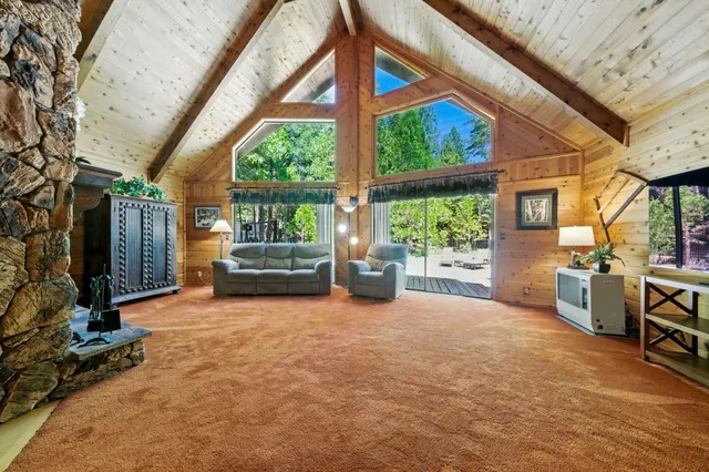 a living room with furniture a bed and large windows
